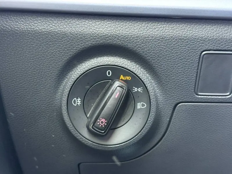 Commande des phares en gros plan sur tableau de bord noir d'une SEAT ARONA 2025, version 1.0 TSI 115ch FR.