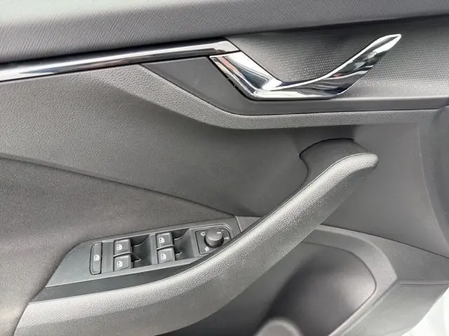 Détail de la porte côté conducteur de la Skoda Scala blanche 2025, avec commandes des vitres et poignée chromée.