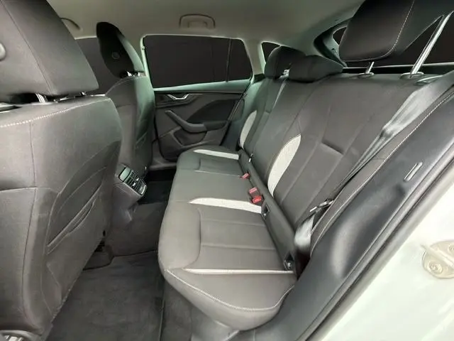 Vue intérieure côté droit de la banquette arrière noire de la Skoda Scala blanche avec ceinture et appuie-têtes visibles.