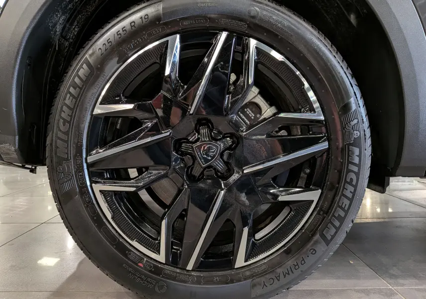 Gros plan sur la jante noire et chromée de 19 pouces d’un Peugeot 5008 Hybrid 2025, pneu Michelin visible.