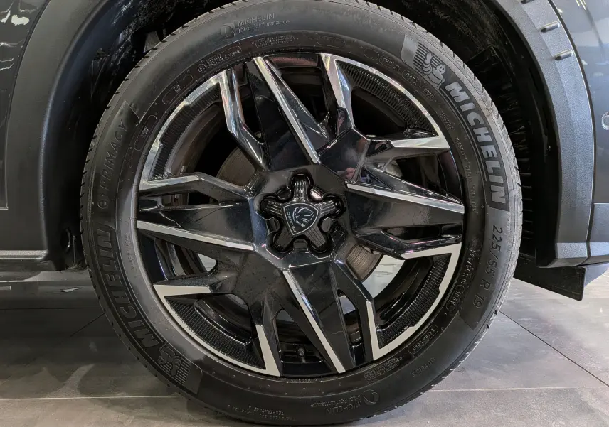 Gros plan sur la jante avant droite noire et argentée du Peugeot 5008 Hybrid 145 CH e-DCS6 GT gris titane.