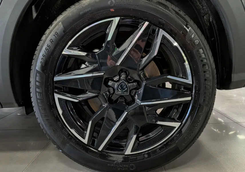 Gros plan sur la jante noire et argentée de 19 pouces d’un Peugeot 5008 Hybrid 2025 gris titane.