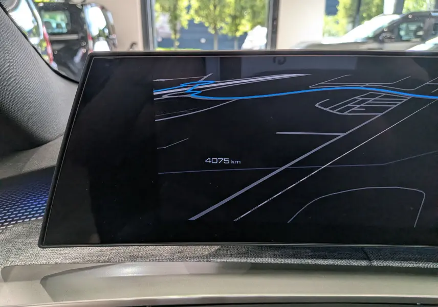 Écran central du tableau de bord du Peugeot 5008 Hybrid 145 GT affichant la navigation et le compteur kilométrique à 4075 km.