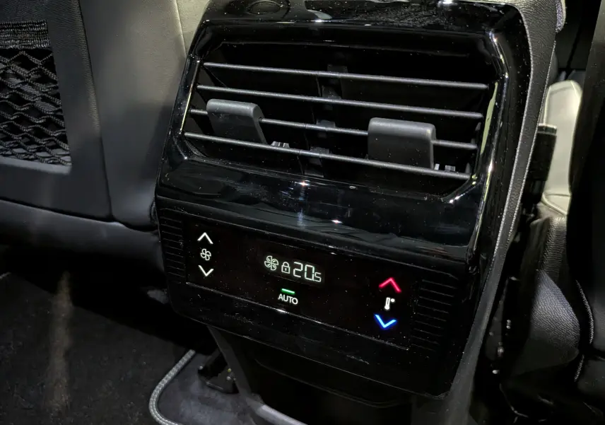Détail de la console arrière noire du Peugeot 5008 Hybrid 2025 avec commandes de climatisation digitale affichant 20,5°C.