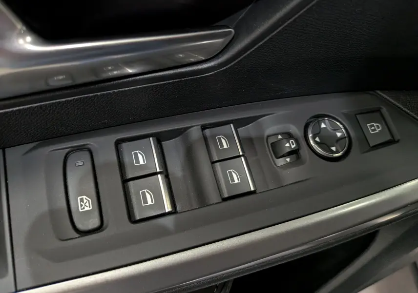 Gros plan sur les commandes de lève-vitres et réglage des rétroviseurs côté conducteur du Peugeot 5008 gris Titane.