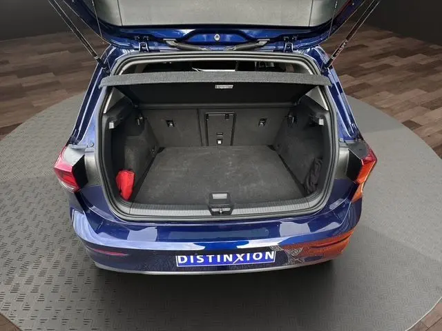 Vue arrière ouverte du coffre d'une Volkswagen Golf VIII bleu 2023, montrant un espace de chargement propre et spacieux.