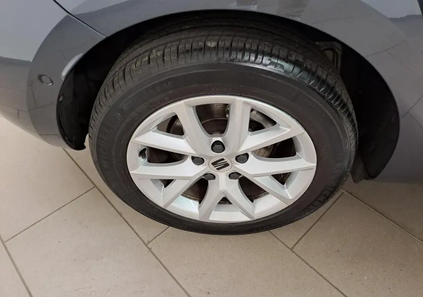 Gros plan sur la roue avant gauche d'une SEAT LEON gris magnétique, mettant en valeur la jante alliage et le pneu Michelin.