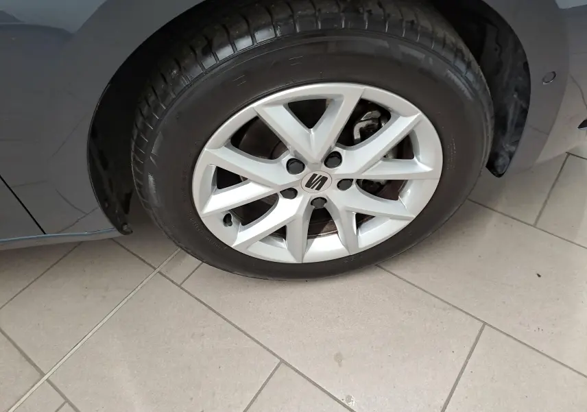 Gros plan sur la roue avant droite d’une SEAT LEON gris magnétique avec jante alliage et logo central visible.