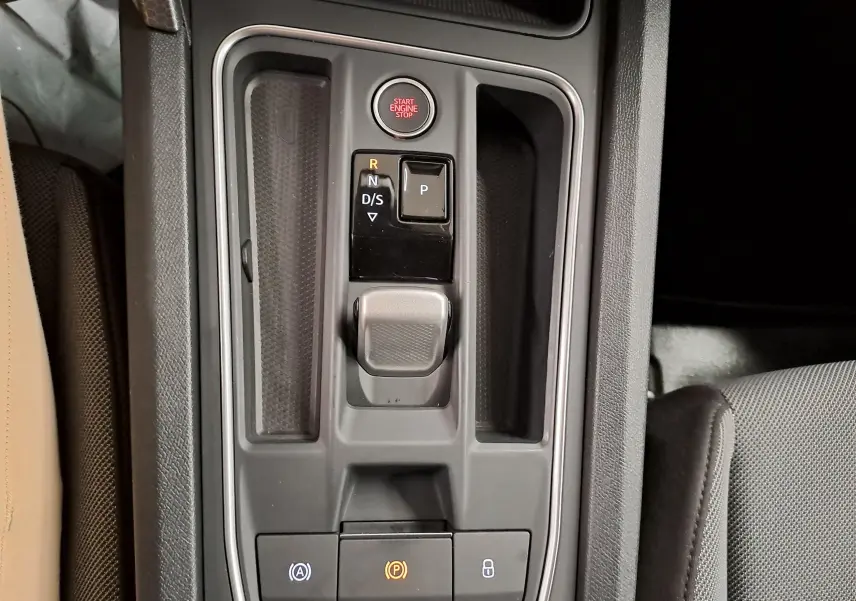 Vue rapprochée de la console centrale du SEAT LEON 1.5 eTSI Hybrid 2025, montrant la commande de boîte automatique et le bouton Start/Stop.