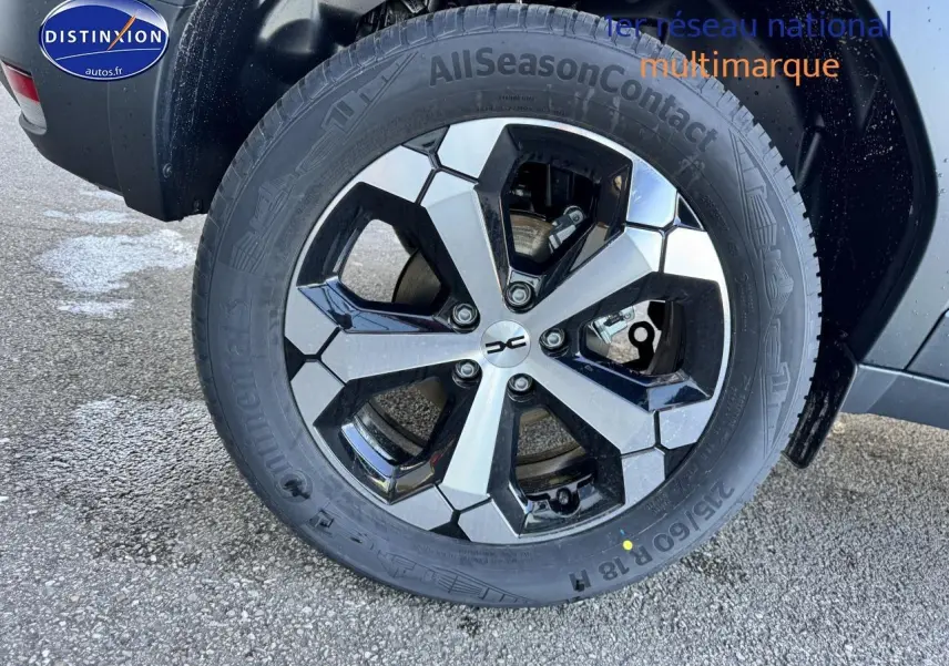 Gros plan sur la roue avant droite du Dacia Duster 2025 vert cèdre avec jante alu noire et argentée.