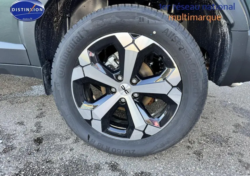 Gros plan sur la roue avant droite du Dacia Duster vert cèdre avec jante alu au design moderne.