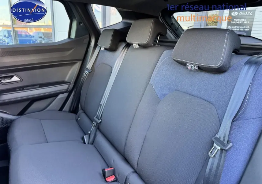 Vue intérieure de la banquette arrière du Dacia Duster 2025, tissu gris foncé avec appuie-têtes et ceintures visibles.