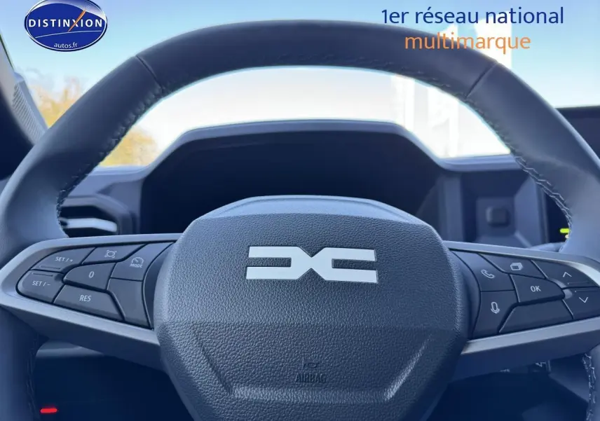 Gros plan sur le volant noir multifonction du Dacia Duster 2025, avec commandes intégrées visibles de face.