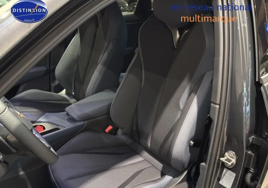 Vue intérieure côté conducteur du CUPRA Terramar gris 2025, mettant en valeur le siège sport et l'accoudoir central.