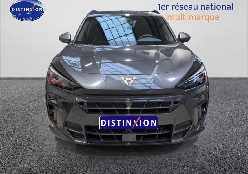 Vue frontale d'une CUPRA Terramar gris métallisé avec calandre large et logo CUPRA doré visible sur le capot.