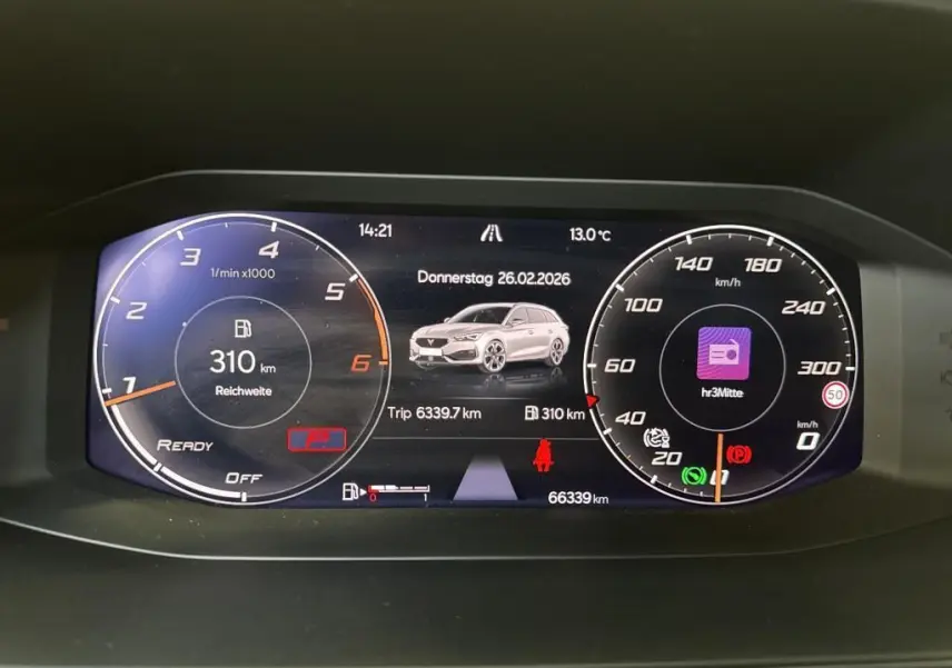 Tableau de bord numérique de CUPRA LEON ST blanc, affichant compte-tours, vitesse, autonomie et informations de trajet.