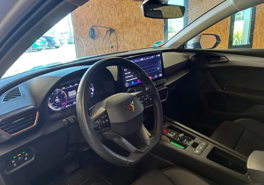 Vue intérieure côté conducteur de la CUPRA LEON ST 2024 avec tableau de bord numérique et volant multifonction noir.
