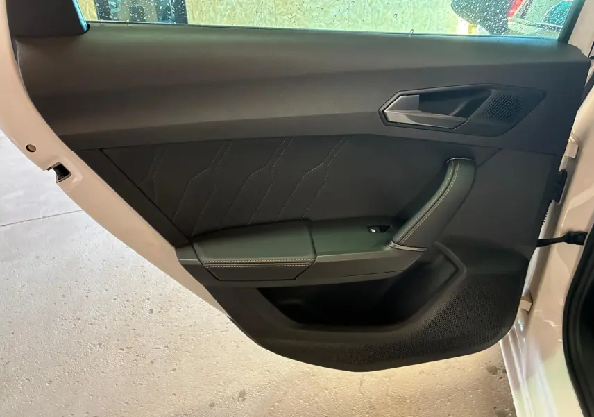 Vue intérieure de la porte arrière droite blanche de la CUPRA LEON ST 2024 avec panneau noir et surpiqûres contrastées.