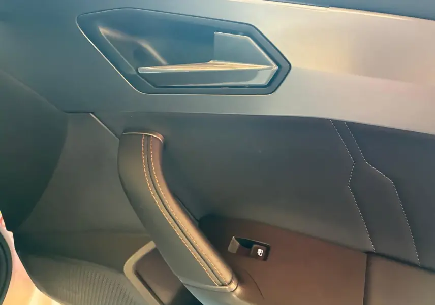 Gros plan sur la poignée de porte intérieure côté gauche en cuir noir avec surpiqûres contrastantes du CUPRA Leon ST 2024.