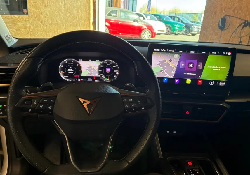 Vue intérieure centrée sur le volant CUPRA et le tableau de bord digital avec écran tactile du Leon ST 2024.