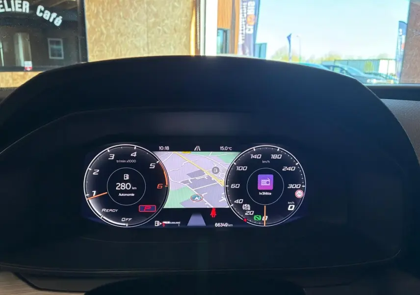 Vue rapprochée du tableau de bord numérique de la CUPRA LEON ST blanc 2024, affichant la navigation et les compteurs.
