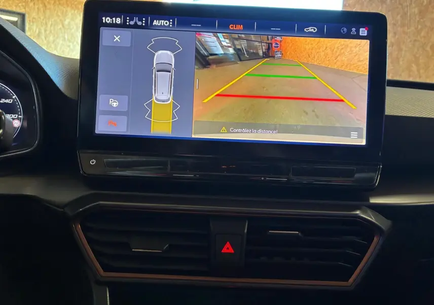 Écran central de la CUPRA LEON ST blanc 2024 montrant la caméra de recul avec lignes de guidage colorées.