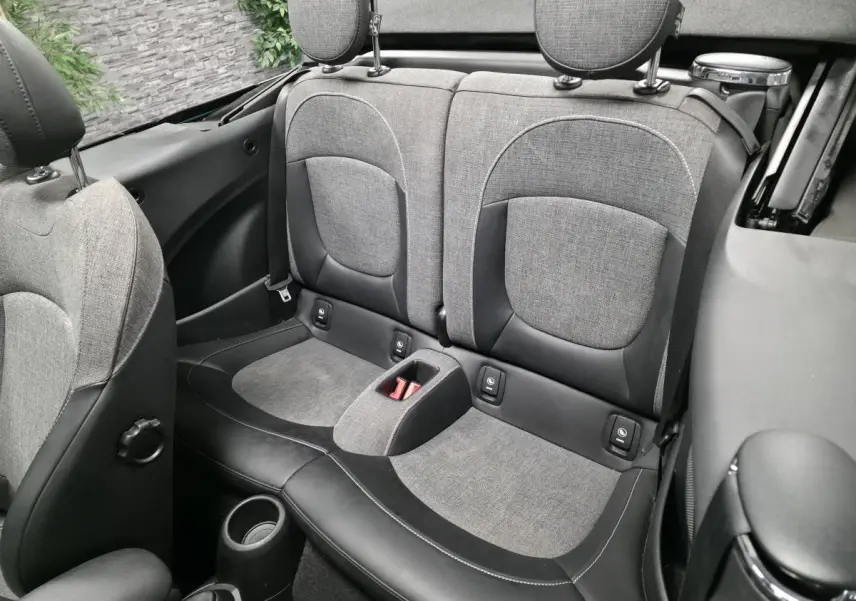 Vue intérieure arrière du cabriolet MINI bleu, montrant la banquette 2 places en tissu gris et cuir noir avec appuie-têtes.