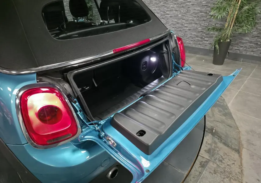 Vue arrière gauche d’un MINI Cabriolet bleu 2017 avec coffre ouvert et capote noire visible.