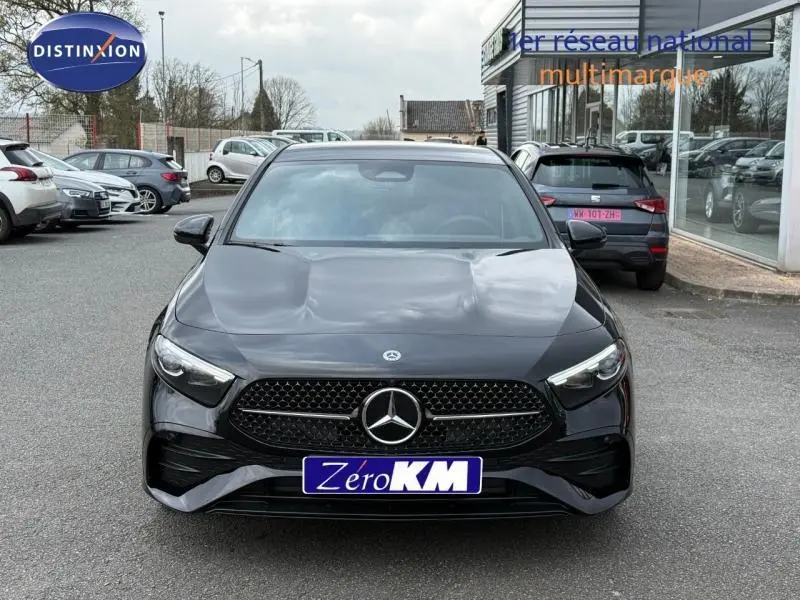 Vue avant d'une Mercedes Classe A 200 d AMG Line gris montagne métallisé avec calandre noire et phares LED allumés.
