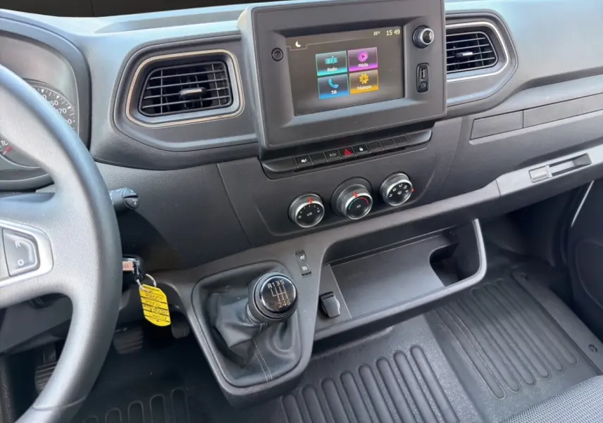 Vue intérieure du tableau de bord du Renault Master 2023, avec écran tactile central et levier de vitesse manuel.
