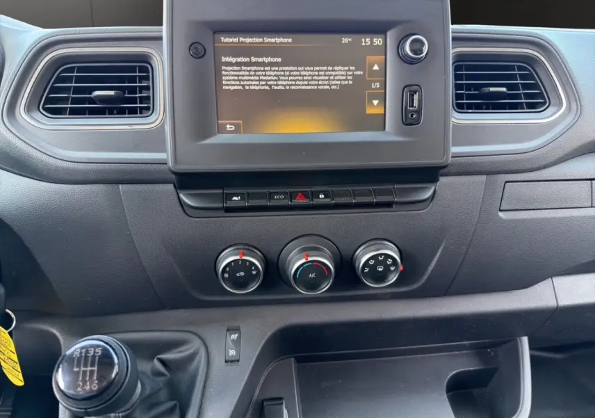 Vue rapprochée du tableau de bord noir du Renault Master 2023 avec écran tactile et levier de vitesse manuel.
