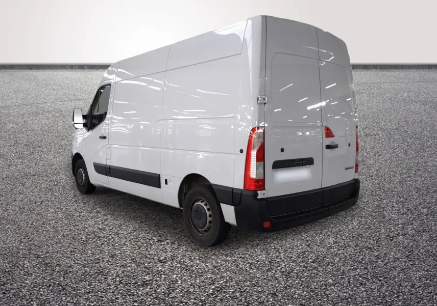 Vue 3/4 arrière droite d’un utilitaire Renault Master blanc avec porte latérale et feux arrière verticaux.