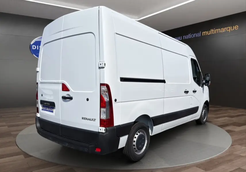 Renault Master blanc en vue 3/4 arrière droit, fourgon utilitaire avec panneaux latéraux lisses et feux arrière verticaux.