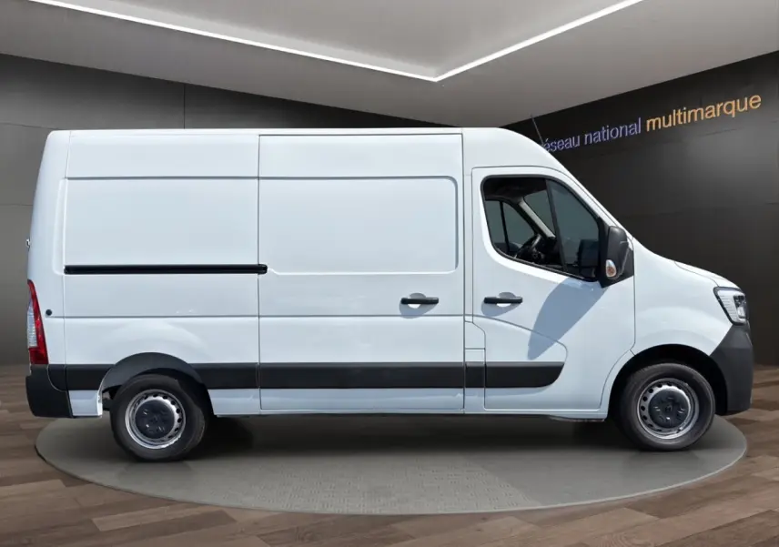 Vue latérale droite d’un Renault Master blanc utilitaire avec cloison pleine et jantes acier noires.