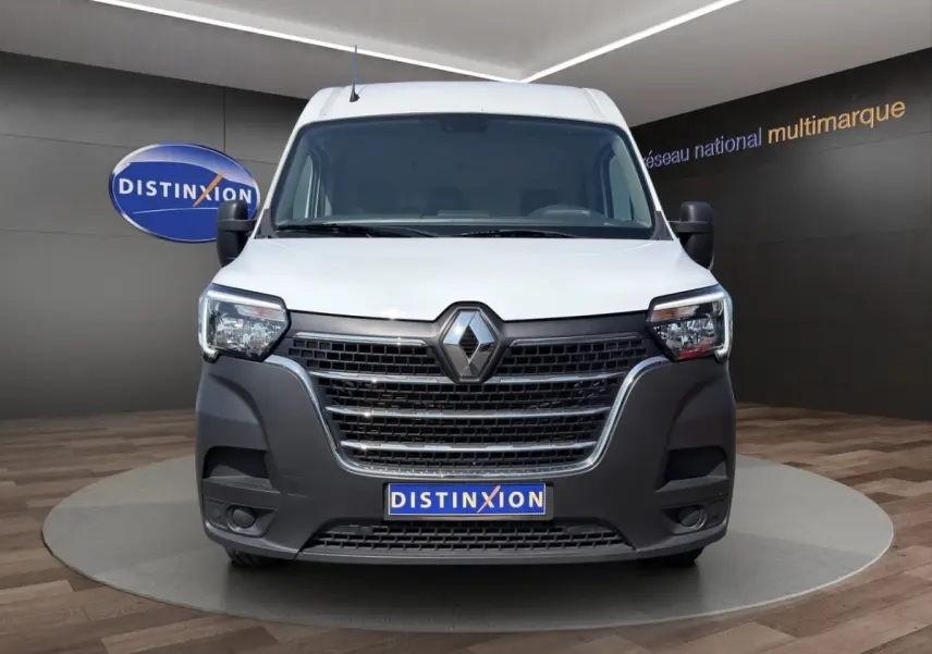 Vue frontale d’un Renault Master blanc avec pare-chocs noir et logo Renault bien visible, en showroom.