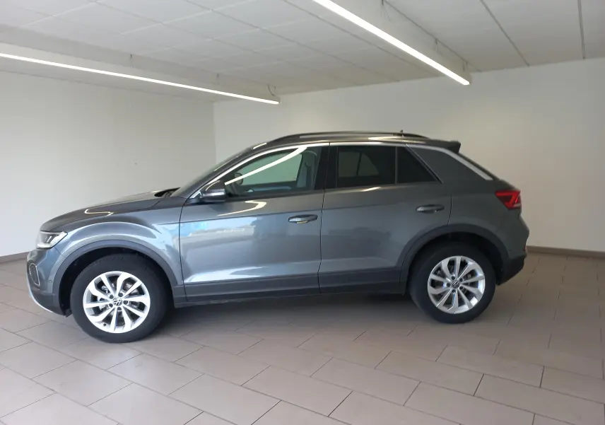 Volkswagen T-Roc 1.5 TSI 150 DSG7 VW Edition gris Indium vu de profil côté gauche en intérieur.