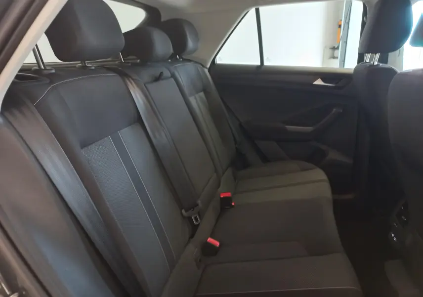 Vue intérieure de la banquette arrière du Volkswagen T-Roc 2025, sièges noirs avec ceinture de sécurité visible.