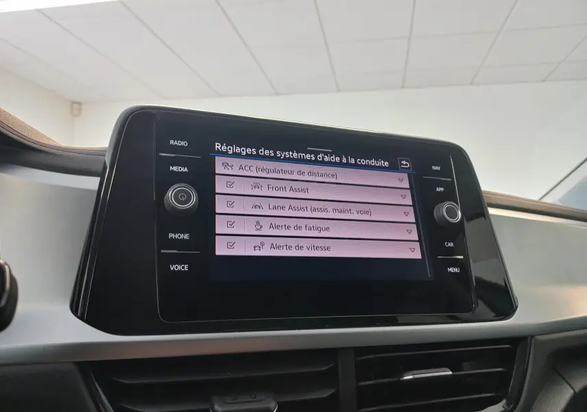 Écran tactile central du Volkswagen T-Roc 2025 gris Indium, affichant les réglages des aides à la conduite.