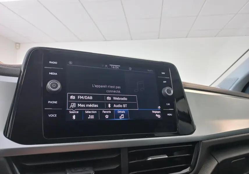 Écran tactile central du Volkswagen T-Roc 2025 gris Indium, vue rapprochée du système multimédia avec options radio et Bluetooth.