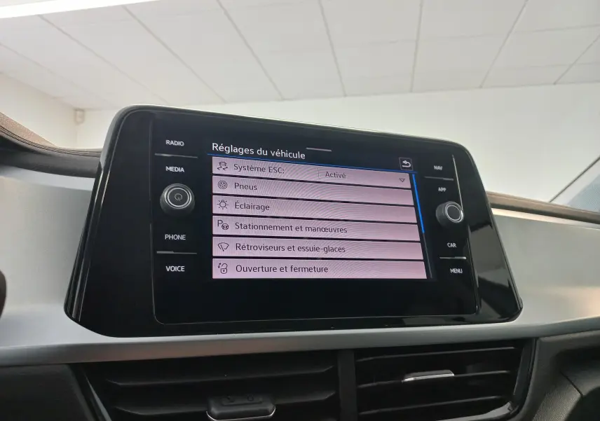 Écran tactile central du Volkswagen T-Roc 2025 gris Indium, affichant les réglages du véhicule en intérieur.