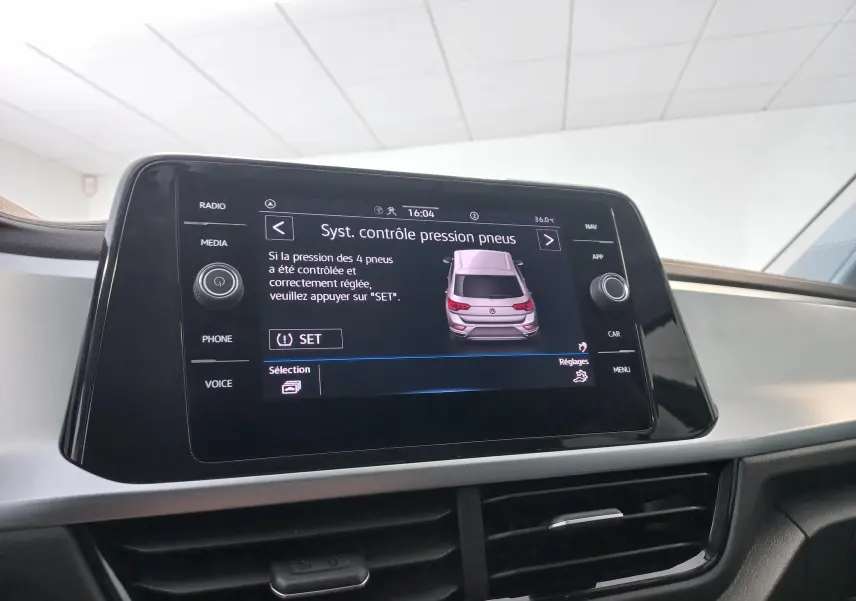 Écran central tactile du Volkswagen T-Roc 2025 affichant le système de contrôle de pression des pneus.