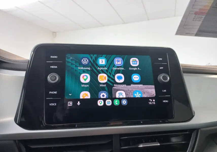 Écran tactile central du Volkswagen T-Roc 2025 affichant des applications connectées, avec commandes autour en noir brillant.