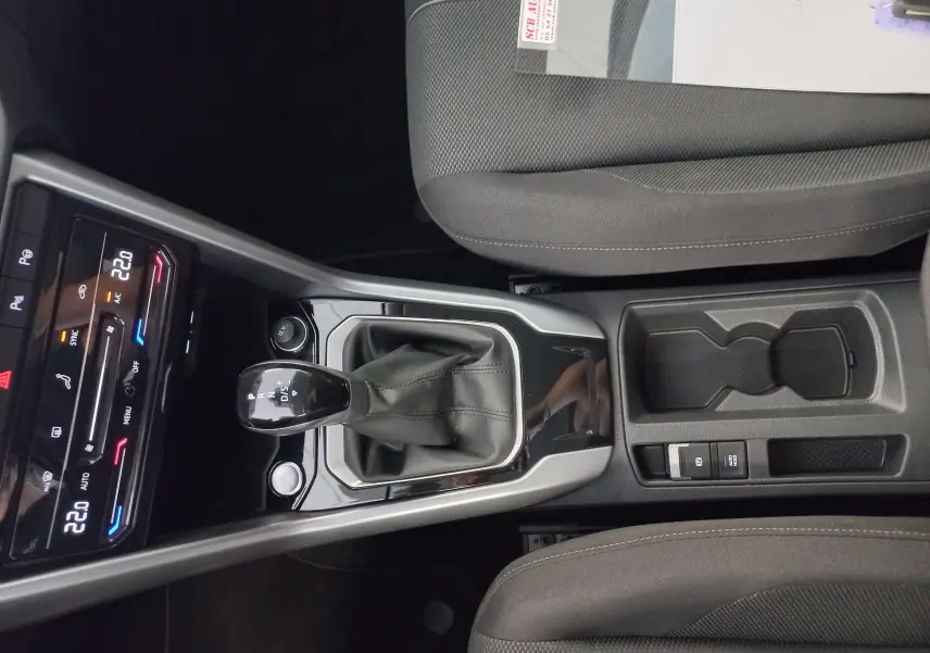 Vue plongeante sur la console centrale du Volkswagen T-Roc 2025, avec levier de vitesse automatique et sièges gris.