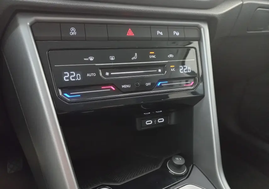 Détail de la console centrale du Volkswagen T-Roc 2025 gris Indium, affichant la climatisation digitale et ports USB.