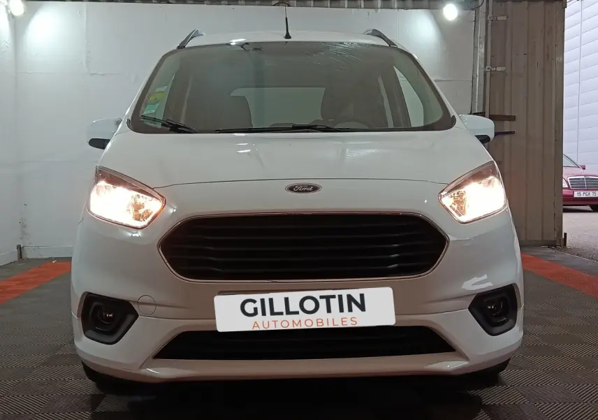 Vue frontale d'un Ford Grand Tourneo Connect blanc de 2020 avec phares allumés et calandre noire.