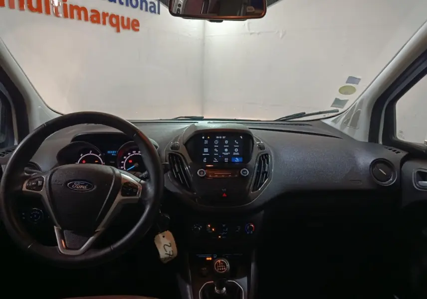 Vue intérieure du tableau de bord noir du Ford Grand Tourneo Connect 2020, avec volant cuir et écran tactile central allumé.
