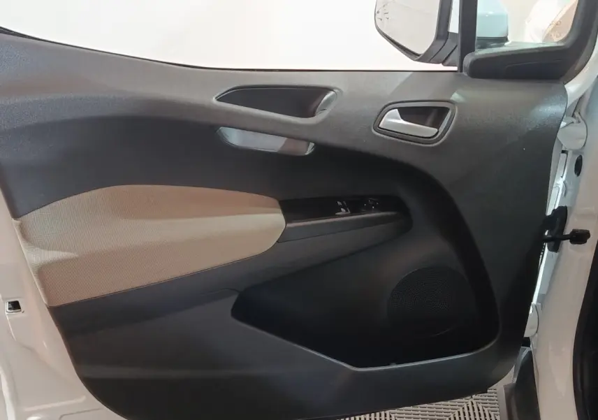 Vue intérieure de la porte avant gauche blanche du Ford Grand Tourneo Connect avec panneau noir et beige et commandes électriques.