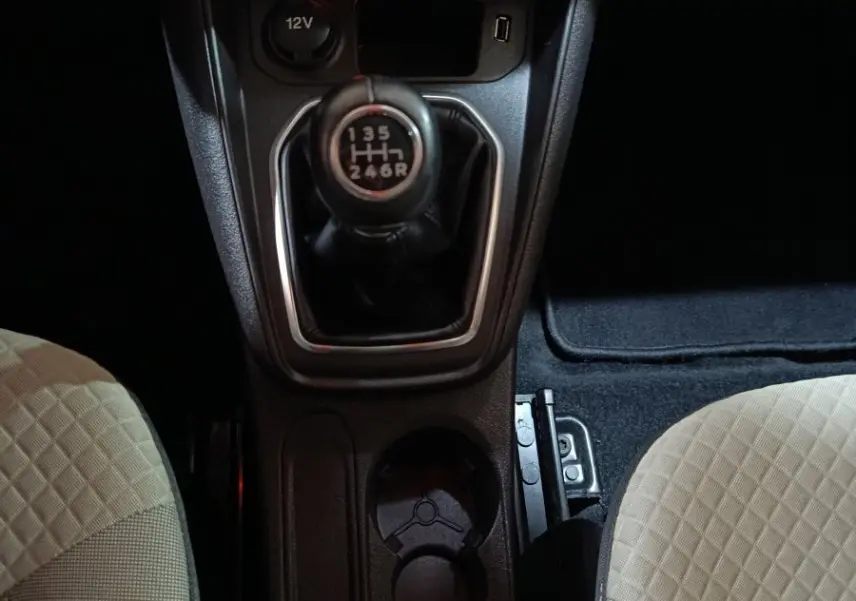 Vue plongeante sur la console centrale du Ford Grand Tourneo Connect 2020, boîte manuelle, sièges beige à motifs.