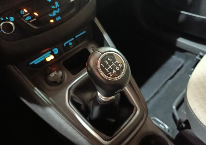 Gros plan sur le levier de vitesses manuel noir du Ford Grand Tourneo Connect 2020, entouré de commandes et prise 12V.