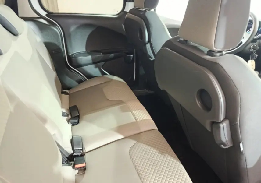 Vue intérieure côté droit sur la banquette arrière beige du Ford Grand Tourneo Connect blanc, avec dossiers avant noirs.
